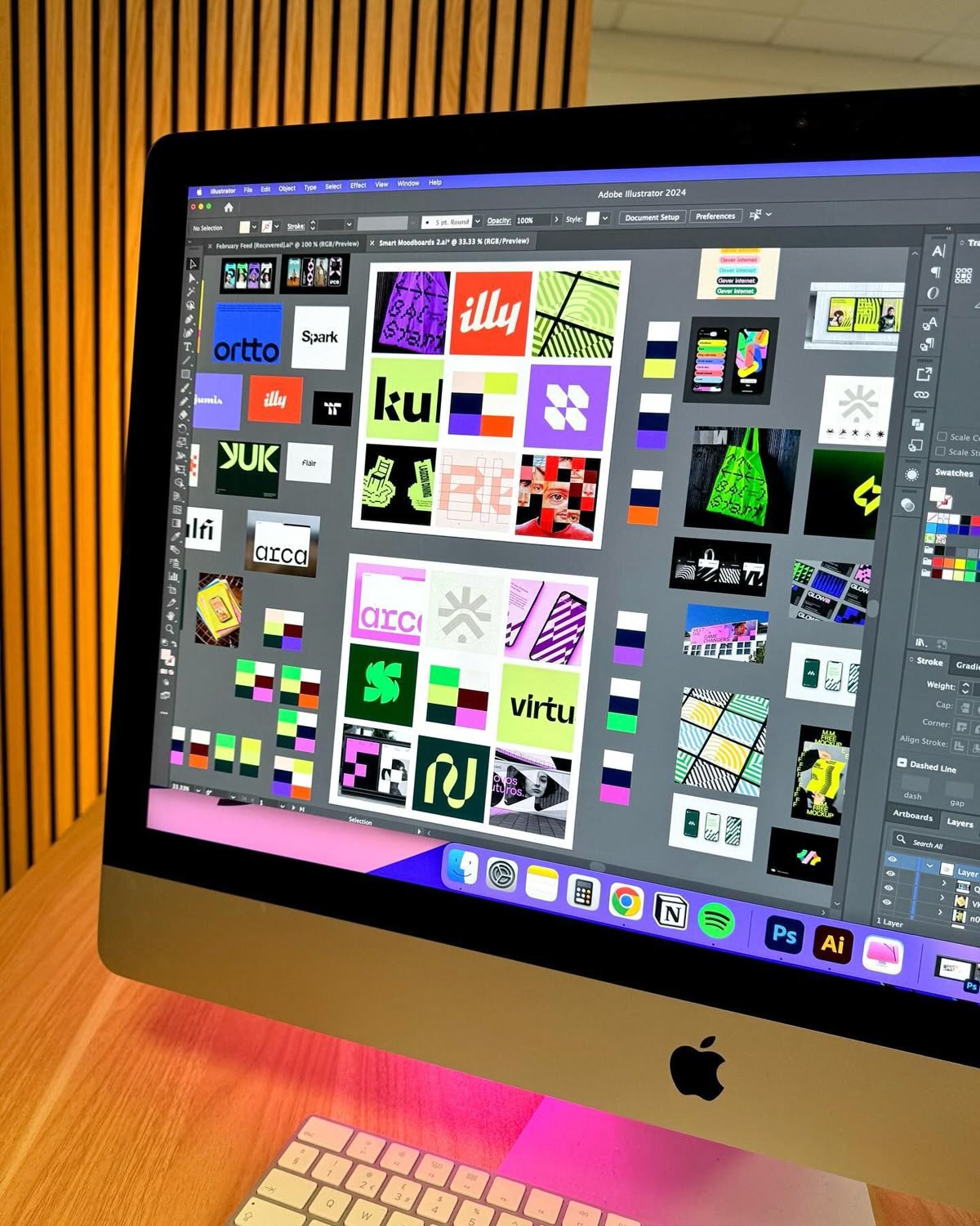 Planche d'identités visuelles ouverte dans Illustrator sur un iMac